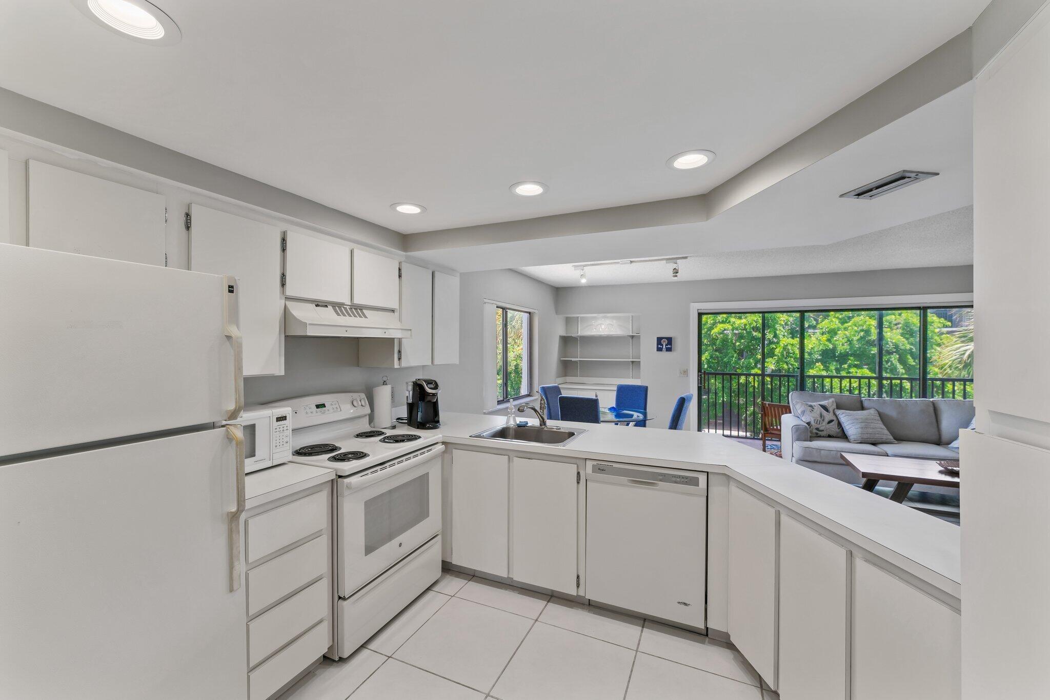 1605 Highway 1, Unit D301 Jupiter, FL 33477 - Photo 16 of 29 a kitchen with white cabinets and white appliances