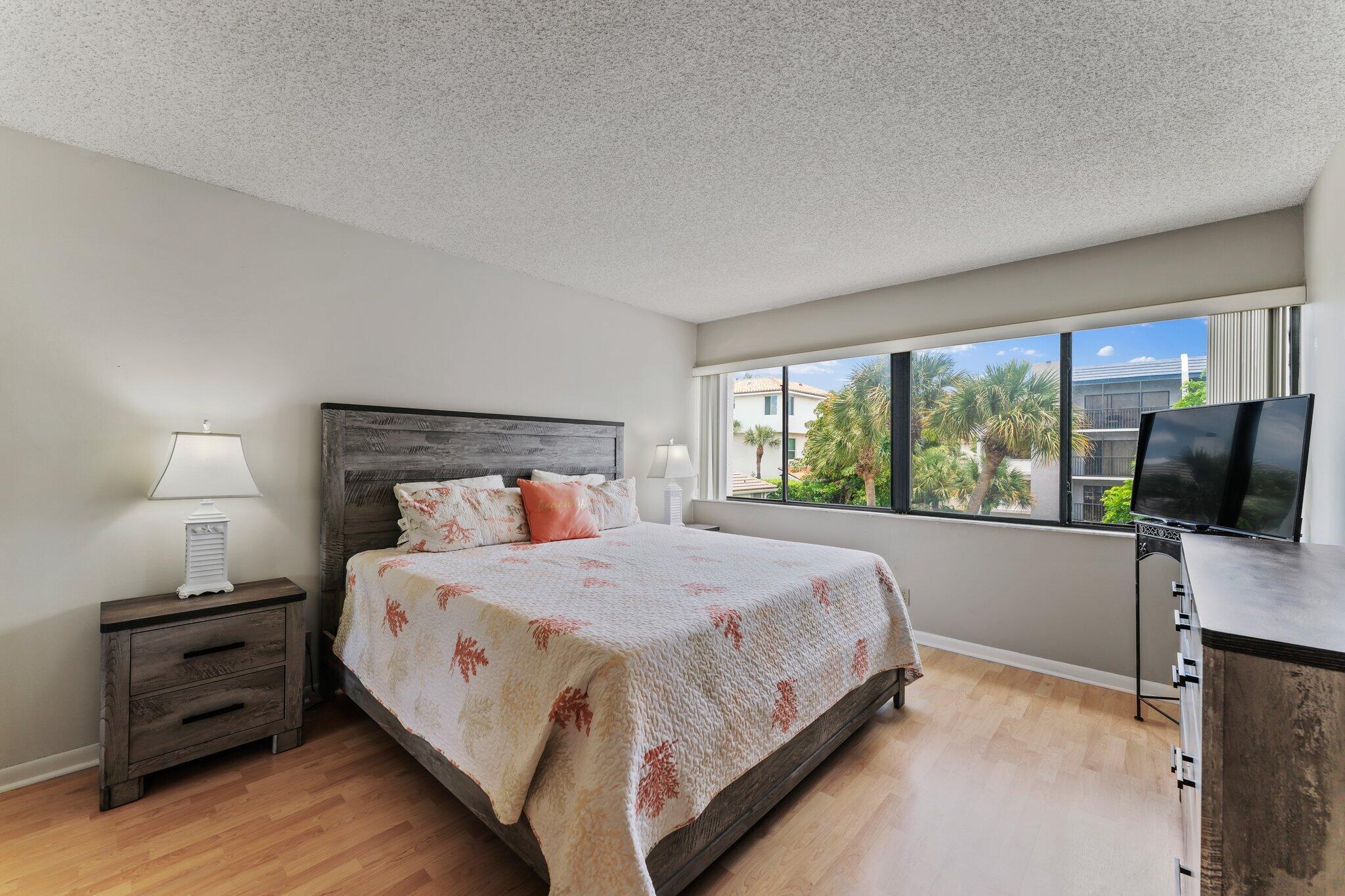 1605 Highway 1, Unit D301 Jupiter, FL 33477 - Photo 23 of 29 a bedroom with a bed and a flat tv screen on a dresser