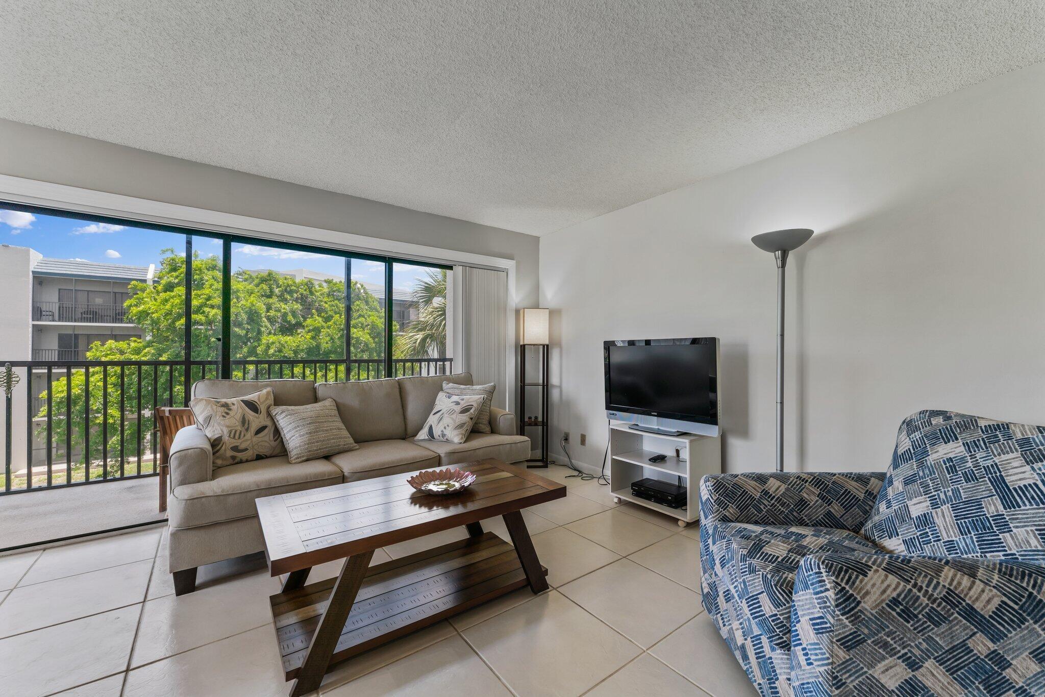 1605 Highway 1, Unit D301 Jupiter, FL 33477 - Photo 8 of 29 a living room with furniture and a flat screen tv