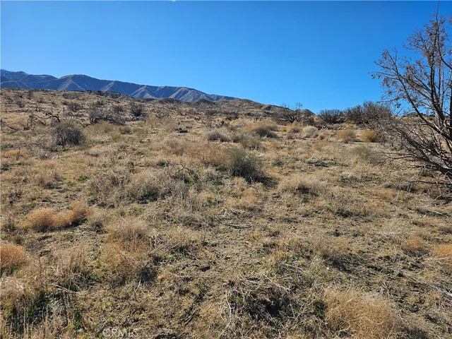 a view of a large mountain with mountains in the background