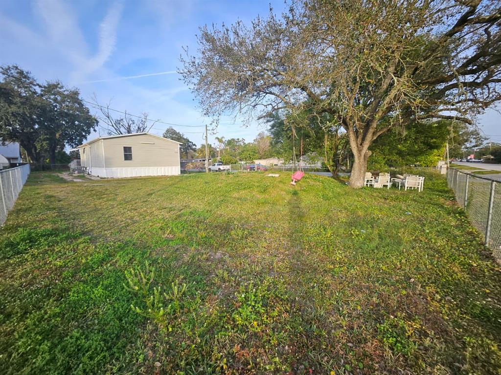129 4th Street Orlando, FL 32824 - Photo 24 of 27 a view of a big yard with large trees and plants