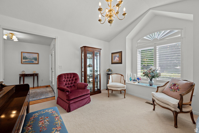 166 South Ridgeview Drive Orem, UT 84058 - Photo 5 of 38 Vaulted ceiling with an ornate chandelier, arched window with plantation shutters, and light-colored carpeting
