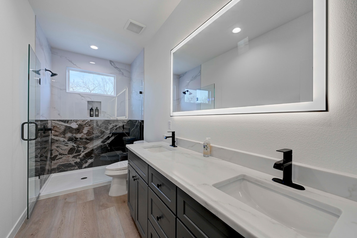 2220 Yellow Jacket Lane, Unit 1 Austin, TX 78741 - Photo 14 of 35 Indulge in a primary bathroom designed for rejuvenation, featuring a dual vanity, sleek flooring, and a spacious shower.