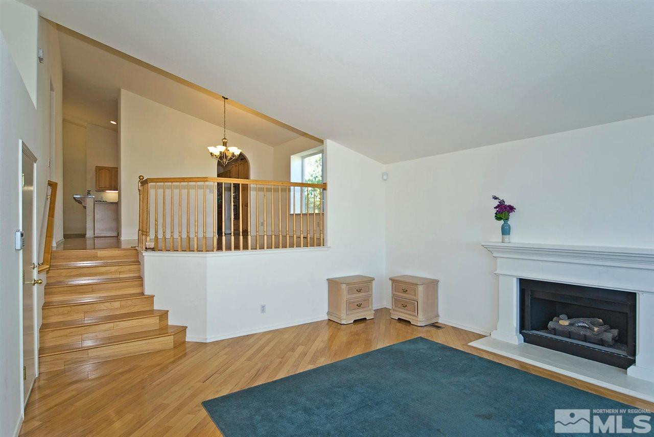 6030 Sunrise Meadows Loop Reno, NV 89519 - Photo 8 of 22 a living room with furniture a fireplace and a table