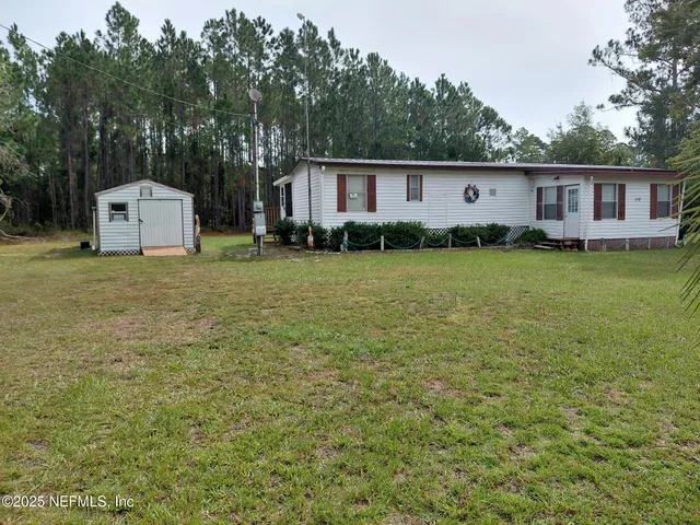 a front view of a house with a yard and trees