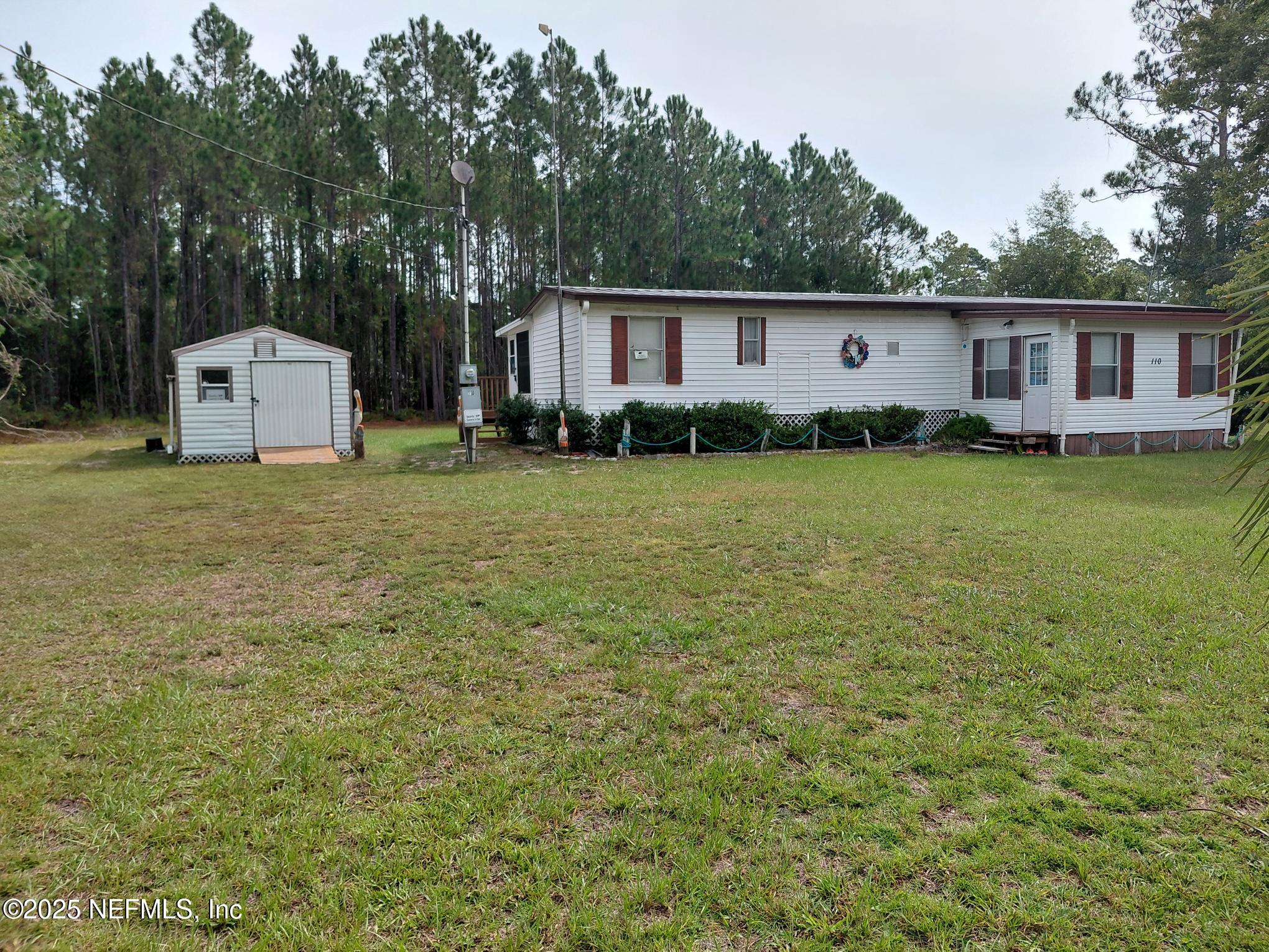 a front view of a house with a yard and trees