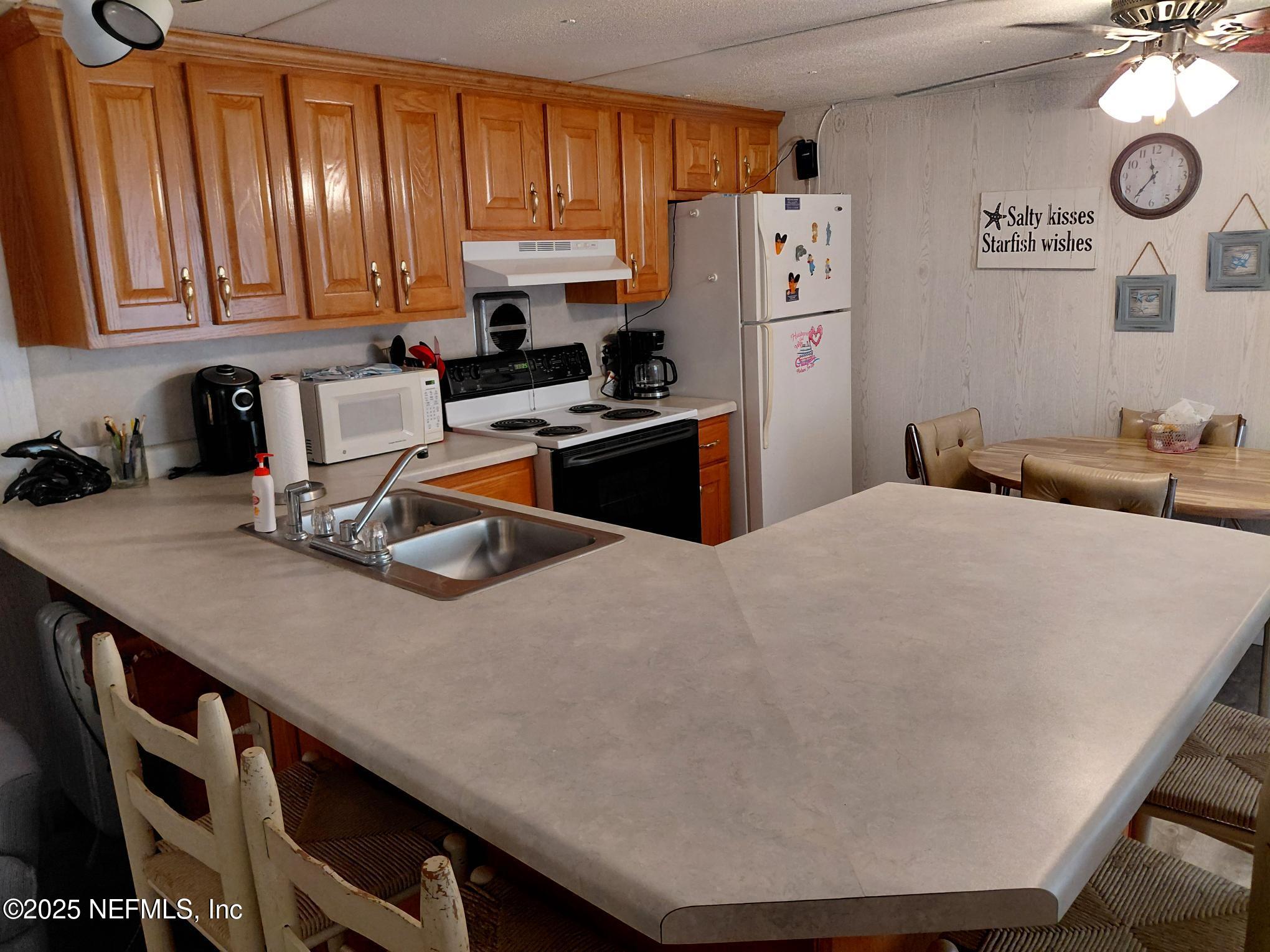 110 Glenside Street Georgetown, FL 32139 - Photo 10 of 18 a kitchen with a appliances a refrigerator and cabinets