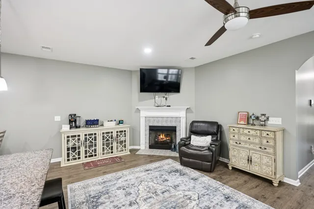 a living room with furniture a fireplace and a flat screen tv