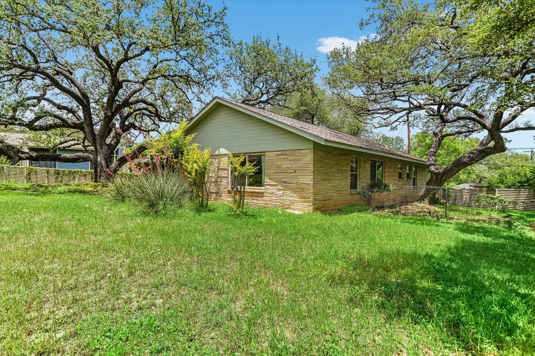 502 Sunset Circle Austin, TX 78704 - Photo 4 of 27 Stone exterior with light green siding and a shingled roof