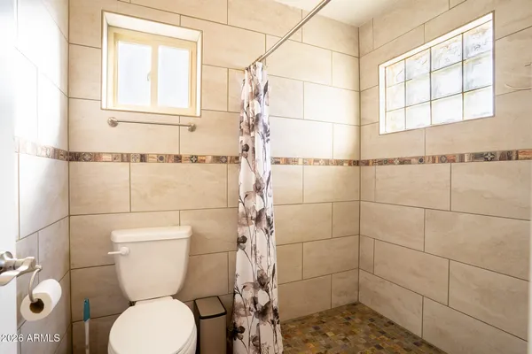 a bathroom with a toilet and a shower