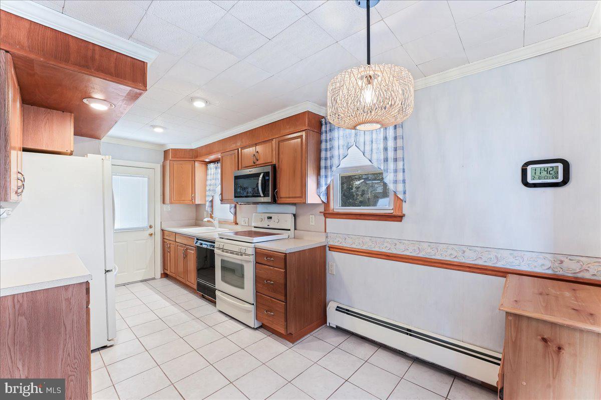 1449 Burmont Road Drexel Hill, PA 19026 - Photo 7 of 27 a kitchen with stainless steel appliances granite countertop a stove a sink and a refrigerator