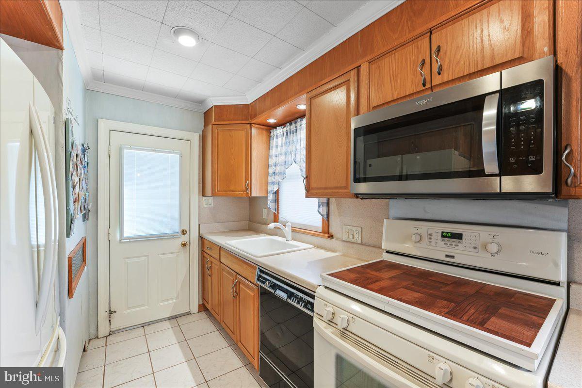 1449 Burmont Road Drexel Hill, PA 19026 - Photo 8 of 27 a kitchen with stainless steel appliances a stove microwave and cabinets