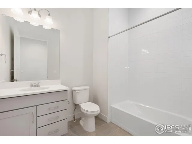 a bathroom with a toilet a sink a mirror and a bathtub