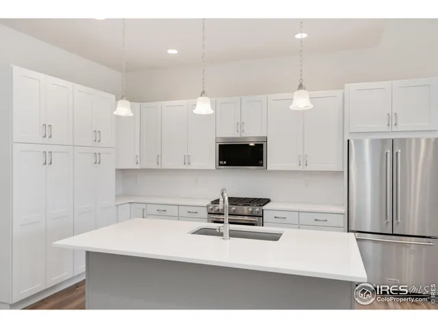 a kitchen with stainless steel appliances a refrigerator sink and microwave