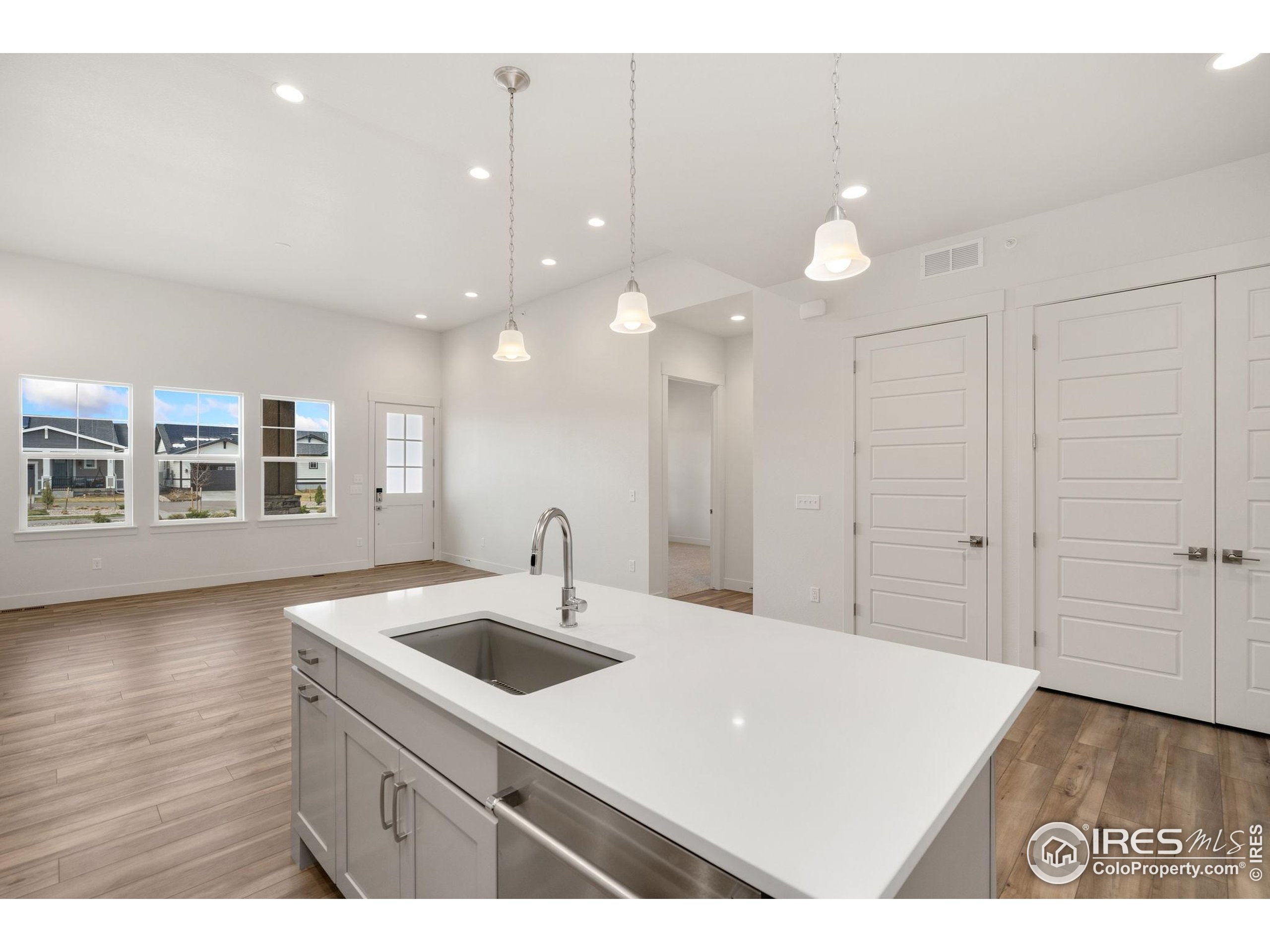2978 Fleet Drive, Unit 4 Fort Collins, CO 80524 - Photo 8 of 17 a kitchen with a sink chandelier and wooden floor