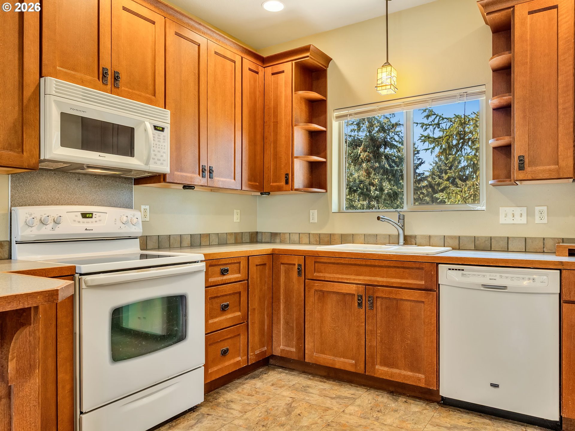 1077 Southwest Ridge Road Warrenton, OR 97146 - Photo 20 of 46 a kitchen with stainless steel appliances granite countertop a sink a stove and a microwave