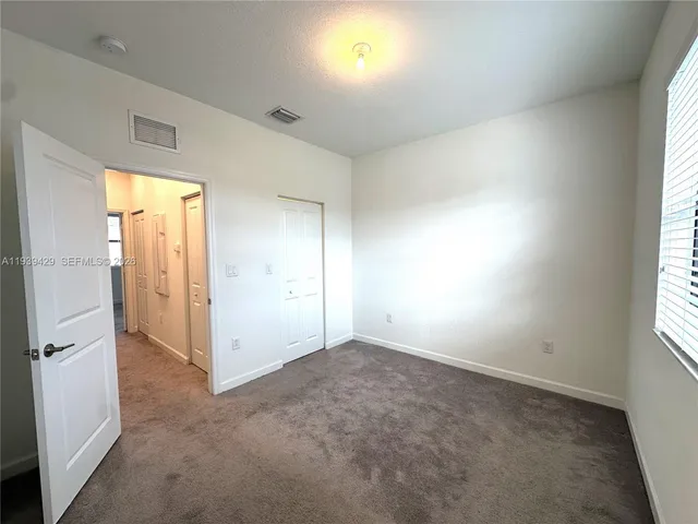 an empty room with windows and closet