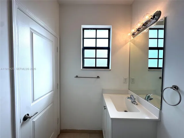a bathroom with a sink a window and shower