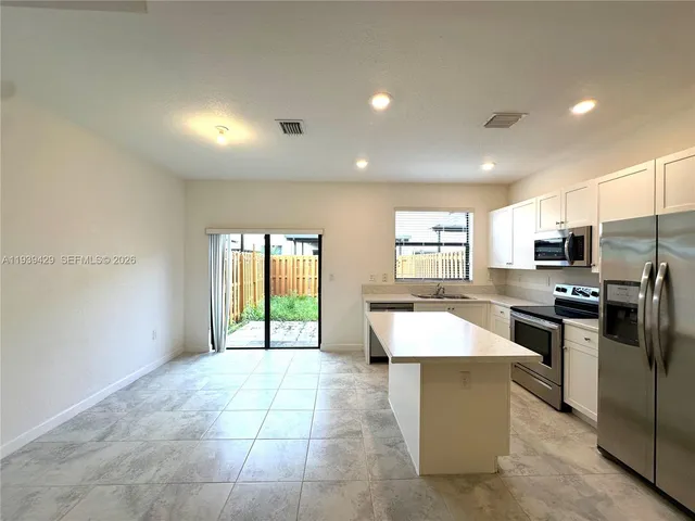 a large kitchen with a large counter top appliances and cabinets