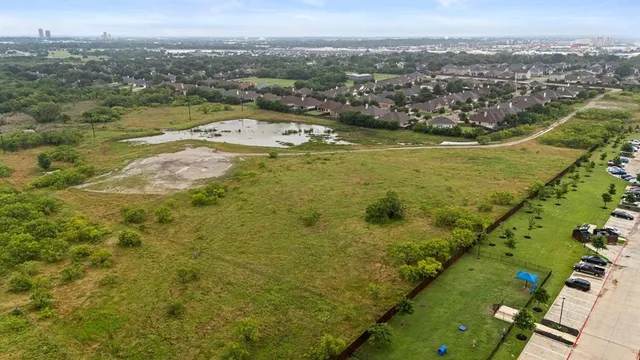 an aerial view of residential houses with outdoor space and trees