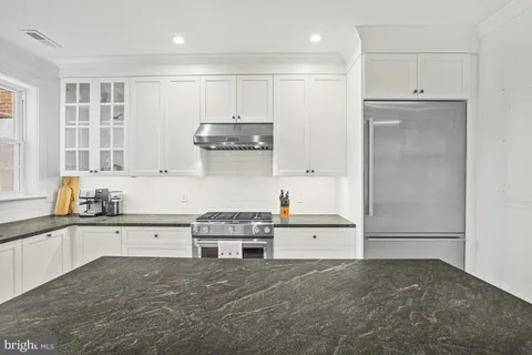 a kitchen with stainless steel appliances granite countertop a refrigerator and a stove top oven