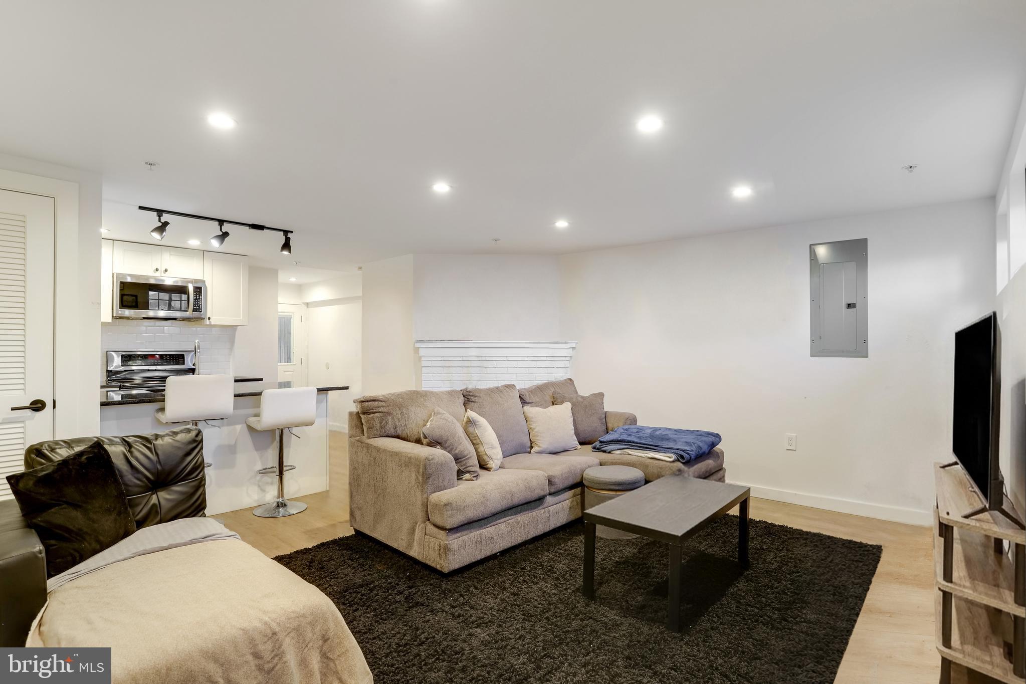 1920 35th Street Northwest Washington, DC 20007 - Photo 32 of 53 a living room with furniture a flat screen tv and kitchen view
