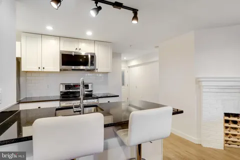 a kitchen that has a sink stainless steel appliances and cabinets