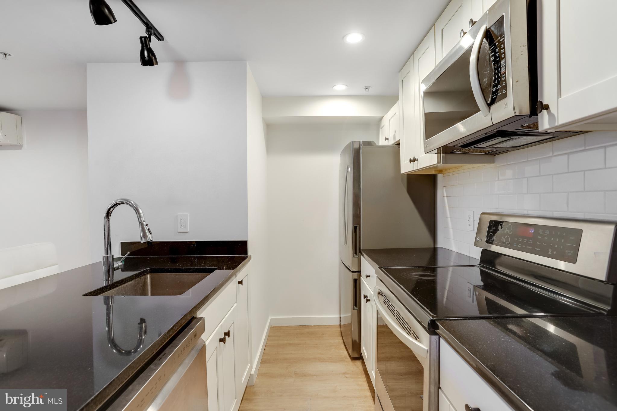 1920 35th Street Northwest Washington, DC 20007 - Photo 37 of 53 a kitchen with stainless steel appliances granite countertop a sink and a stove top oven with granite countertops