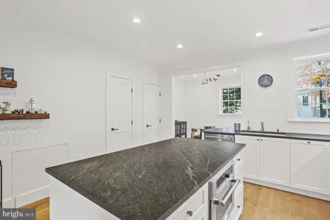 a kitchen with a sink a counter top space and living room
