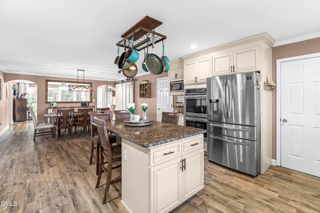 a kitchen with stainless steel appliances granite countertop a refrigerator and a stove top oven