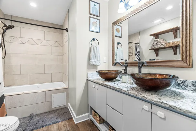 a bathroom with a granite countertop sink a toilet and shower