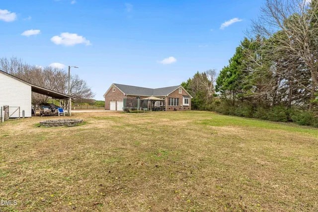 a house view with swimming pool and trees in the background