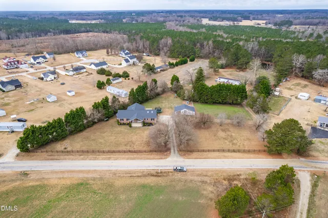 an aerial view of a house with a yard and lake view