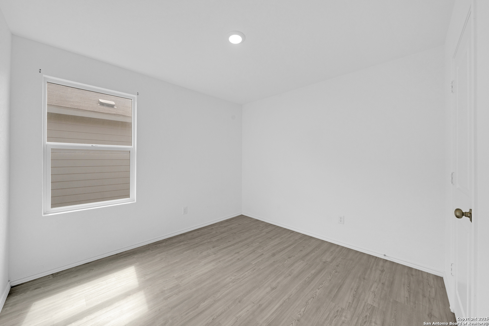 242 Ambush Ridge San Antonio, TX 78220 - Photo 11 of 15 a view of an empty room with wooden floor and a window