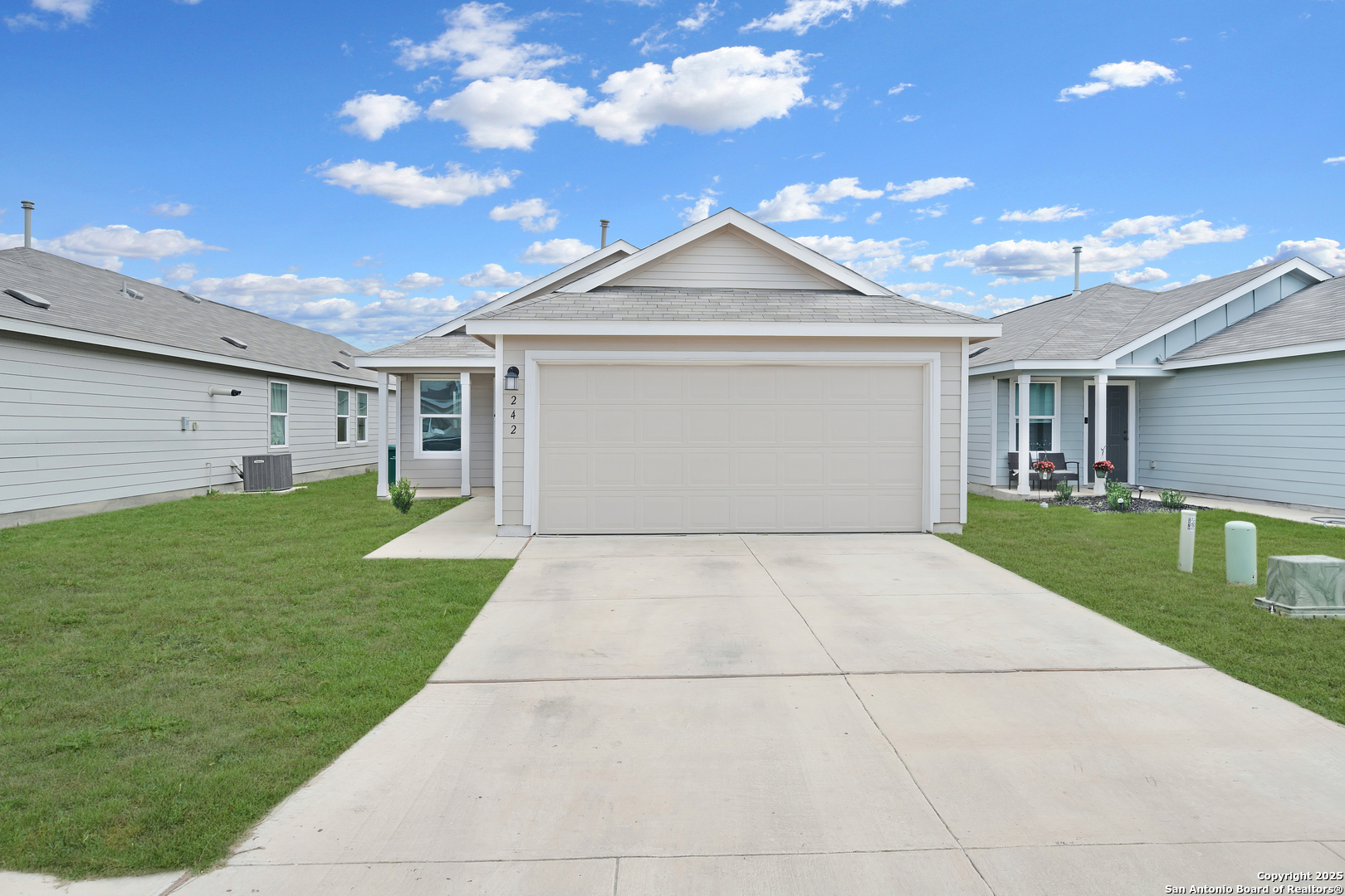 242 Ambush Ridge San Antonio, TX 78220 - Photo 2 of 15 a front view of a house with a yard and garage