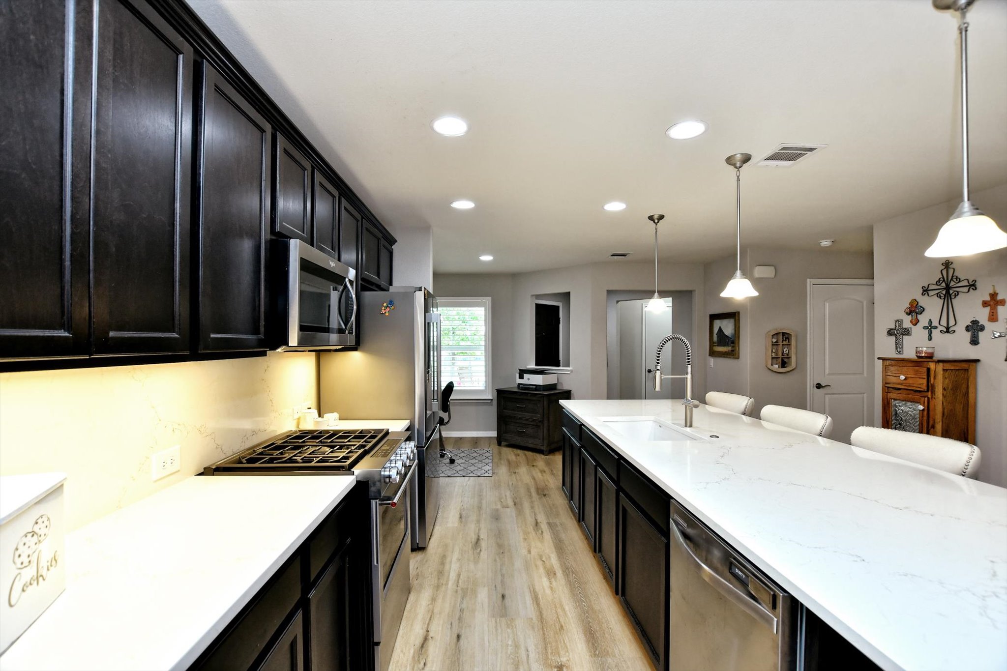 231 Hobby Street Georgetown, TX 78633 - Photo 11 of 29 An inviting kitchen features a spacious island with seating and modern stainless steel appliances.