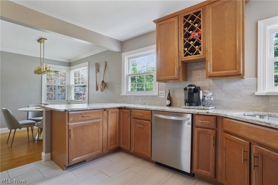1150 Garman Road Akron, OH 44313 - Photo 13 of 38 Kitchen with pendant lighting, light hardwood / wood-style floors, light stone counters, and stainless steel dishwasher