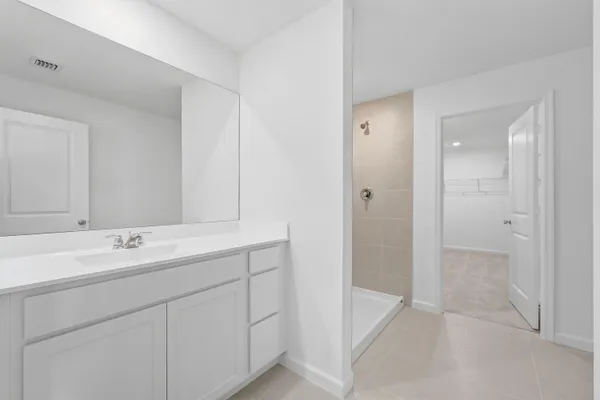 a spacious bathroom with a shower sink and mirror
