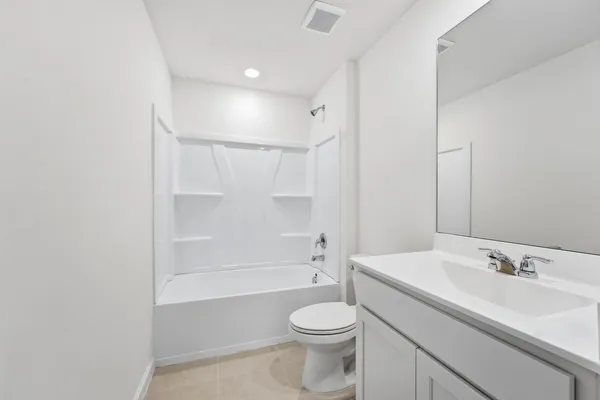 a bathroom with a bathtub shower sink vanity and toilet