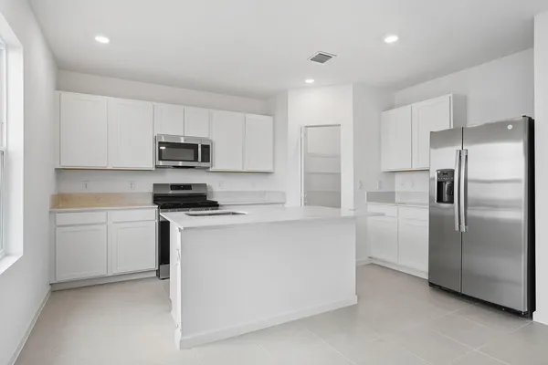 a kitchen with cabinets stainless steel appliances and a counter space