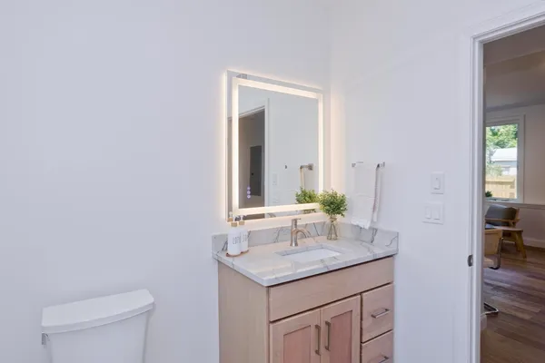 a bathroom with a granite countertop sink and a mirror