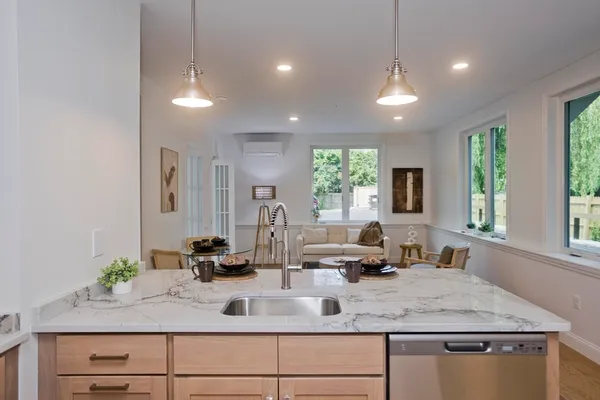 a kitchen with a granite countertop sink window and a white counter top