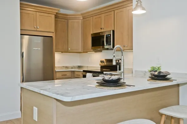 a kitchen with stainless steel appliances granite countertop a sink a stove and a microwave