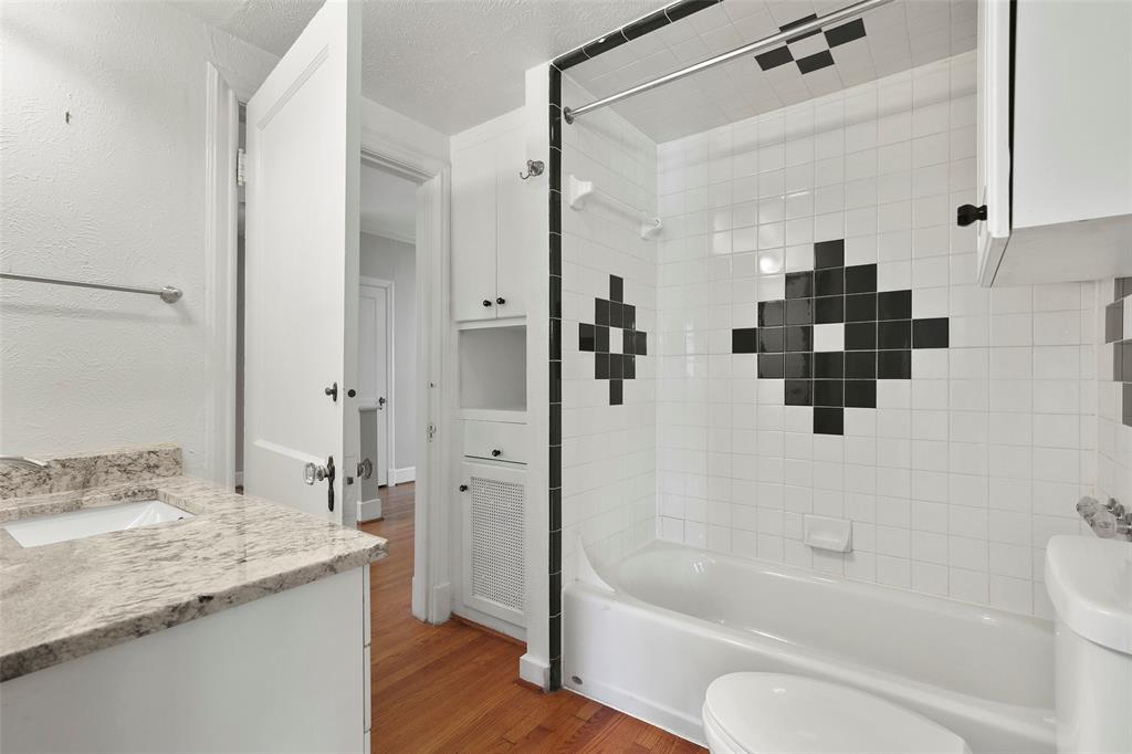 6166 Oram Street Dallas, TX 75214 - Photo 17 of 25 a bathroom with a granite countertop sink a toilet and shower