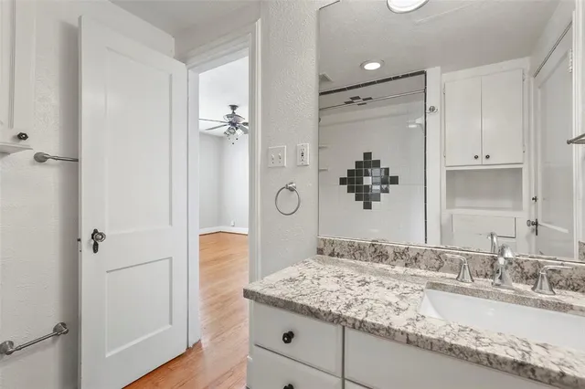 a bathroom with a granite countertop sink and a mirror