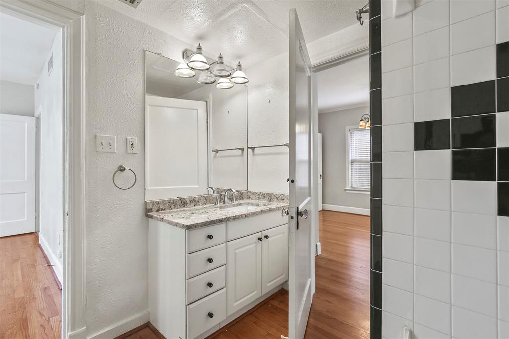 6166 Oram Street Dallas, TX 75214 - Photo 19 of 25 a spacious bathroom with a granite countertop sink a mirror and shower