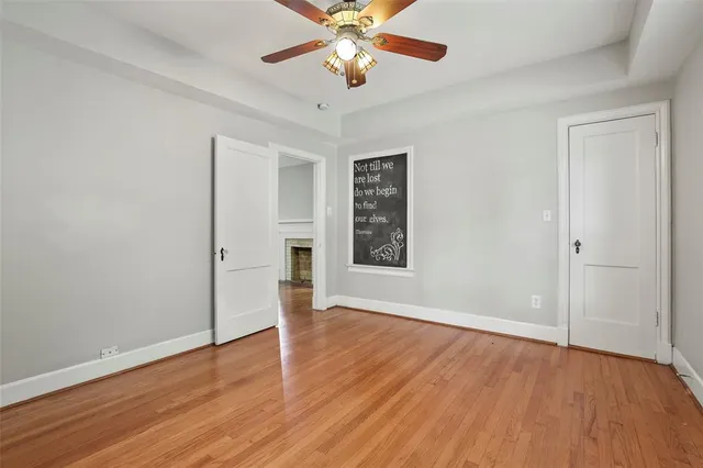 an empty room with wooden floor chandelier fan and closet area