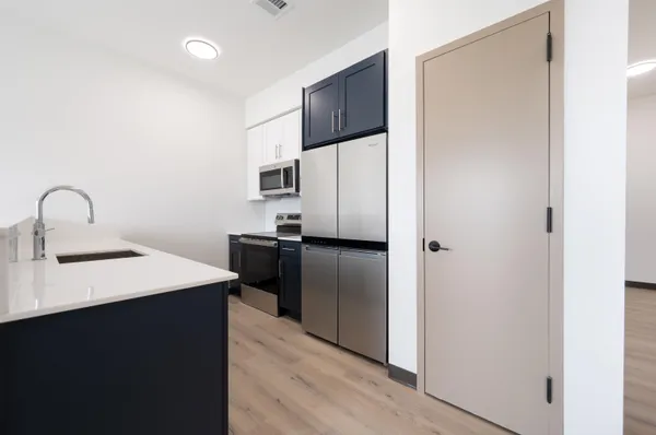 a kitchen with a sink a refrigerator and cabinets