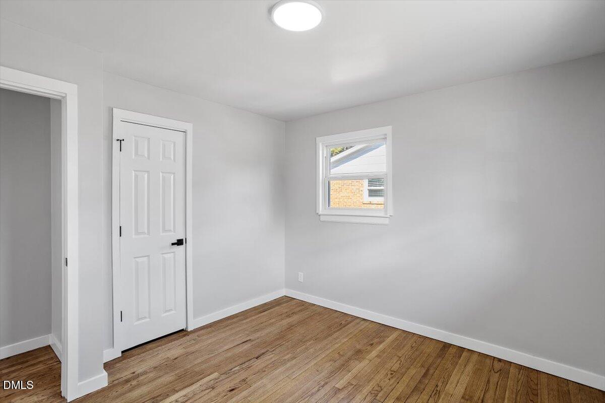 1905 Capps Street Durham, NC 27707 - Photo 28 of 35 a view of an empty room with wooden floor and a window
