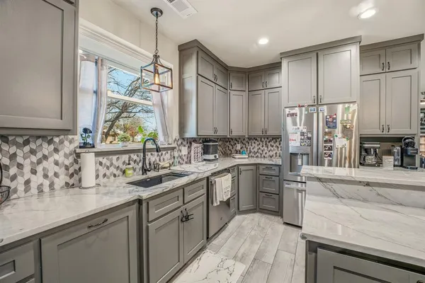 a kitchen with stainless steel appliances granite countertop a sink stove and refrigerator
